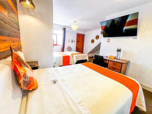 阿亚库乔Ayacucho Plaza的一间酒店客房,设有两张床和电视