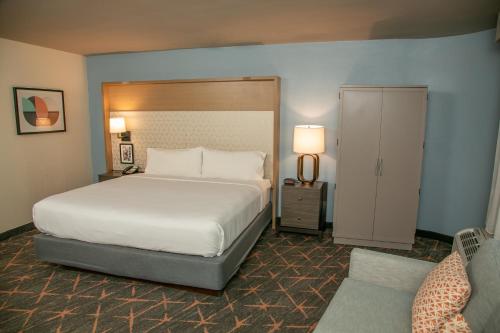 格雷特纳新奥尔良西岸大厦假日酒店的一间卧室配有一张大床,并设有一个通往衣柜的门。