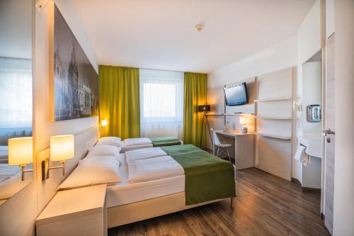 菲沙门德多夫维也纳机场生活酒店的配有一张床和一张书桌的酒店客房