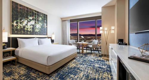 拉斯维加斯Las Vegas Hilton at Resorts World的酒店客房,配有一张床和一张桌子及椅子