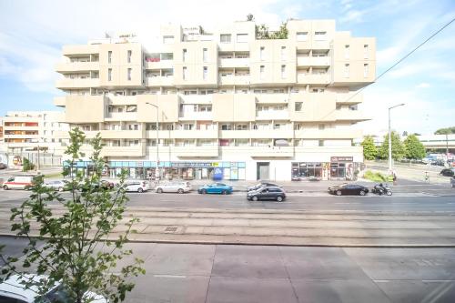 维也纳Spacious Apartment in Floridsdorf Area PR9的一座白色的大建筑,汽车停在停车场