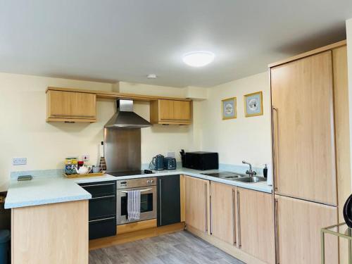 史云顿Luxury apartment in Swindon town centre -sleeps 4的厨房配有黑色家电和木制橱柜