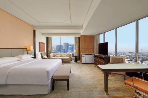 雅加达雅加达甘达利雅城喜来登大酒店的酒店客房设有一张大床和一间客厅。