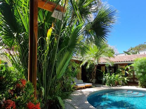 萨玛拉Villas Kalimba的棕榈树庭院和房子中的游泳池