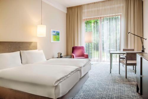 布拉格布拉格NH精选酒店的配有一张床和一张书桌的酒店客房