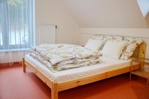 布尔诺梅姿斯托米旅馆 的一间卧室配有一张带白色床单和枕头的木制床。