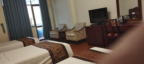 胡志明市Ngọc Lan Hotel的酒店客房设有三张床和电视。