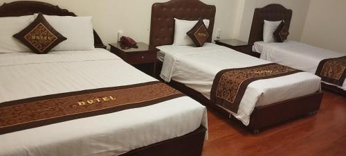 胡志明市Ngọc Lan Hotel的一间酒店客房,房间内设有三张床