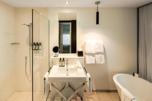 皇后镇皇后镇公园精品酒店的浴室配有盥洗盆、浴缸和浴缸。