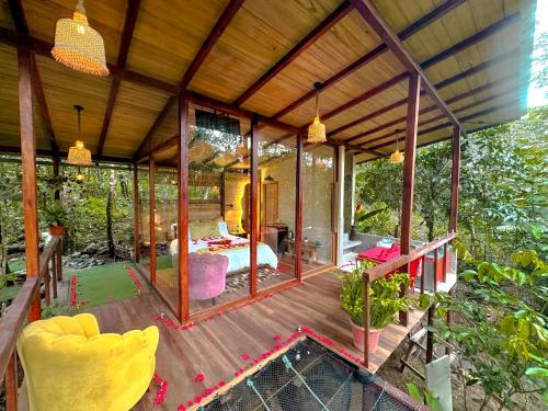 TarquiPuyu Glamping的木甲板上配有床的玻璃房子