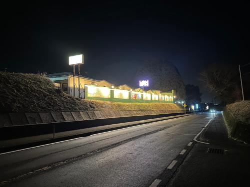 TanigashiraホテルZERO的一条空的街道,晚上有灯的建筑