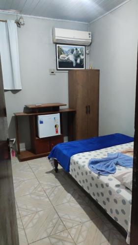 吉巴拉那Pousada ji Paraná的一间卧室配有一张床、一张书桌和一台电视。
