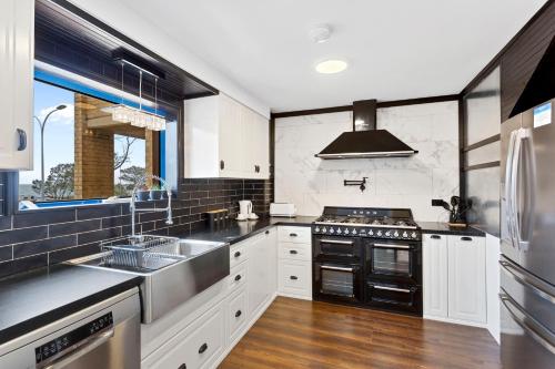珀斯Nautica Residences Hillarys的厨房配有白色橱柜和黑色家电