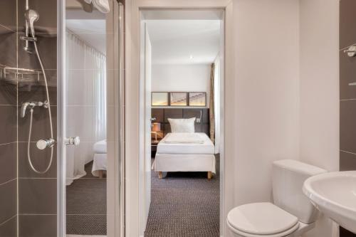 美因茨Waldhotel的一间带卫生间的浴室和一张位于客房内的床。