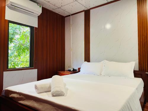峰牙Huy-Mountainside Homestay的一间卧室设有两张带白色床单的床和窗户。