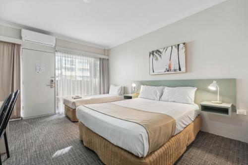 阿德莱德Glenelg Dockside Motel的酒店客房设有两张床和窗户。