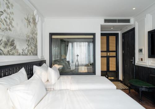 河内Paradise Suites Truc Bach lake的一间卧室配有两张带白色枕头的床