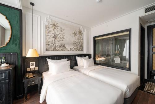河内Paradise Suites Truc Bach lake的配有白色床单的客房内的两张床