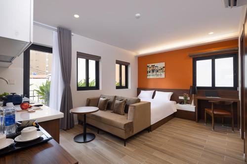 胡志明市Terracotta Villa Saigon的酒店客房配有一张床、一张沙发和一张书桌。