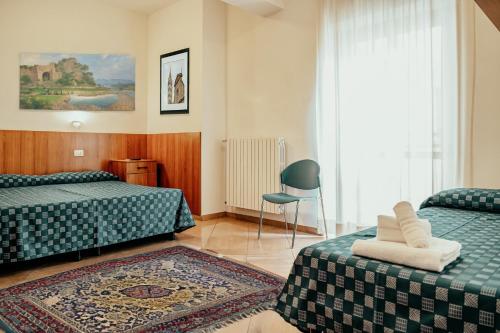 维泰博Nazareth Residence的酒店客房,配有两张床和椅子