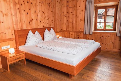 纳兹-夏韦斯Huberhof的一间卧室配有一张带木墙和窗户的床。