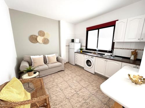 阿雷西费Mahostly Apartamento Comillas PH的厨房以及带沙发和微波炉的客厅。