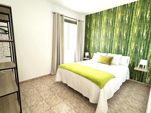 阿雷西费Mahostly Apartamento Comillas PH的一间卧室配有一张带绿色壁纸的床