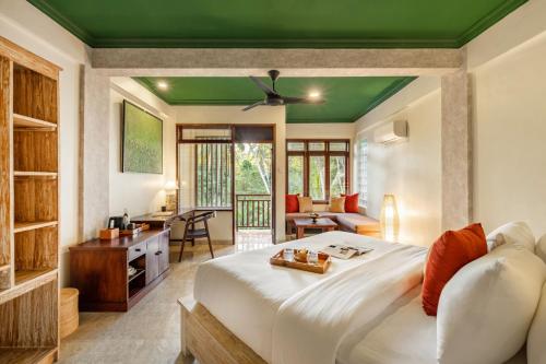 乌布Semana Residences by Cove的一间卧室设有一张白色大床和绿色天花板