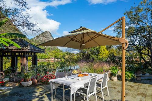 桂林桂林和舍花园小院的露台的遮阳伞下的桌椅