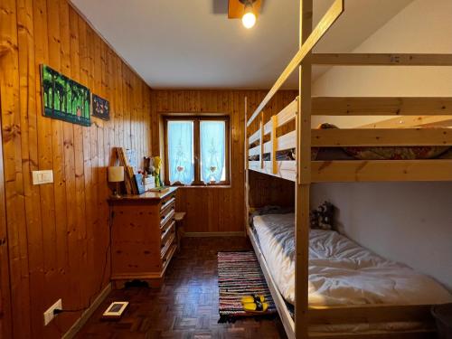 佩利扎诺Casa ai Caprioli的一间卧室配有两张双层床和一张书桌