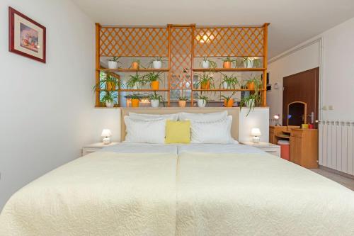 普拉Studio Apartment Oliva的卧室配有一张白色大床,架子上种有植物