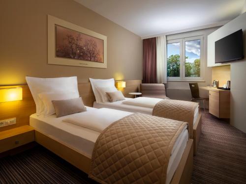 卢布尔雅那Ahotel Ljubljana的酒店客房设有两张床和电视。