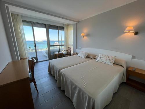 阿兰扎达Hotel La Lanzada的酒店客房设有两张床,享有海景。