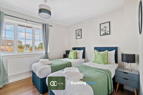 HooWaterside House By OC House Short Lets & Serviced Accommodation Gillingham, Ramsgate, Folkestone With Beautiful River View的绿白色客房内的两张床