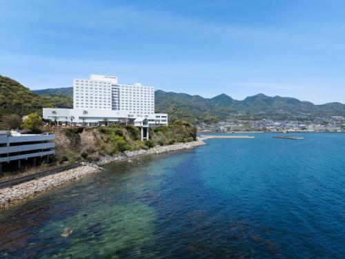 别府Grand Mercure Beppu Bay Resort & Spa的水体边的大建筑