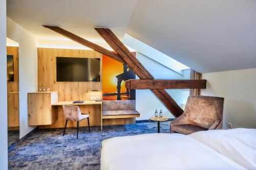 阿尔特廷Hotel Zur Post Altötting的酒店客房,配有一张床、一张桌子和椅子