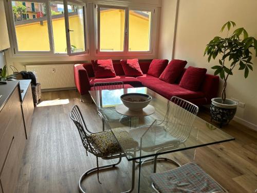 瓦伦纳Varenna Guest House的客厅配有红色的沙发和玻璃桌