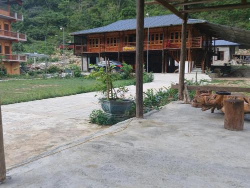 高平Tày Homestay Pác Bó - Cao Bằng的一座大型木制建筑,设有种植了植物的庭院