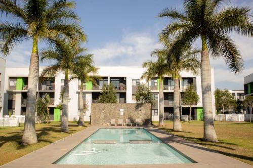 巴利托Modern 2 Bedroom 2 Bathroom Apartment Incl Gym的公寓大楼设有游泳池和棕榈树