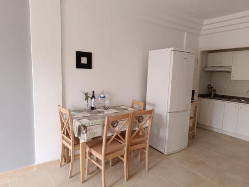 阿德耶Apartamentos ORLANDO en Costa Adeje的厨房配有桌椅和冰箱。