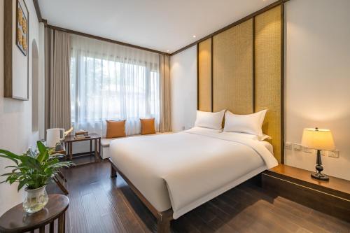 北京北京呆住幽兰酒店的卧室设有一张白色大床和一扇窗户。