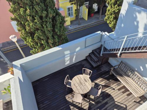 开普敦德沃特坎别墅酒店的阳台配有桌椅,设有楼梯