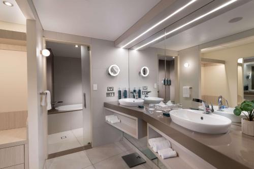 达尔文达尔文希尔顿酒店的一间带两个盥洗盆和大镜子的浴室
