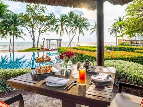 华欣华欣莫维皮克阿萨拉水疗及度假酒店的一张带食物的桌子,享有海景