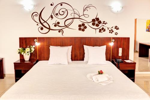 明德卢Hotel LIVVO Don Paco的一间卧室配有一张大床和木制床头板