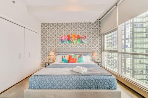 卡尔加里Luxury 2BR Condo - King Bed - Stunning City Views的一间卧室设有一张大床和大窗户
