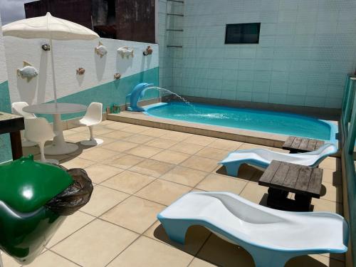 阿拉卡茹Pousada Santa Fé的一间带游泳池、桌子和椅子的浴室
