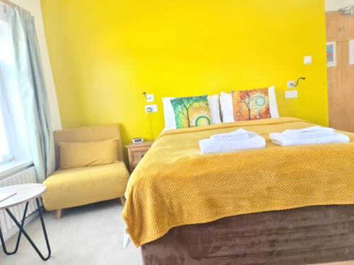 佩恩顿The Torland - Paignton Seafront - free parking and wifi, all rooms en-suite的黄色卧室,配有床和椅子