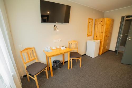 KuremaaKuremaa Külalistemaja的客房配有桌椅和冰箱。