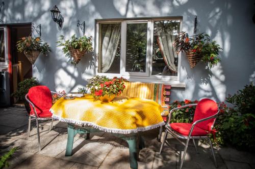 法伦福尔Herlihy's, Half-Way-House的一张桌子、红色的椅子和一张鲜花桌子